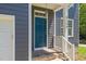 Close up of home's entrance with blue front door, brick steps, and decorative light fixture at 9508 Waterwood Ct, Raleigh, NC 27614
