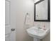 Compact half bath with pedestal sink, mirror, and towel ring at 9508 Waterwood Ct, Raleigh, NC 27614