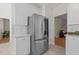 Modern kitchen with stainless steel refrigerator, white cabinets, and easy access to living area at 9508 Waterwood Ct, Raleigh, NC 27614