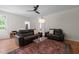 Inviting living room featuring hardwood floors, neutral walls, and comfortable leather sofas at 9508 Waterwood Ct, Raleigh, NC 27614