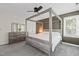 Bright main bedroom featuring a four-poster bed, soft carpet, and abundant natural light at 9508 Waterwood Ct, Raleigh, NC 27614