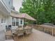 Spacious back deck featuring outdoor seating, a large umbrella, and a view of the backyard at 1005 Fairfax Woods Dr, Apex, NC 27502