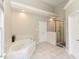 Bathroom featuring a soaking tub with tile surround and a walk-in shower with glass surround at 1005 Fairfax Woods Dr, Apex, NC 27502