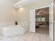 Bathroom featuring a soaking tub with tile surround, and access to the bedroom at 1005 Fairfax Woods Dr, Apex, NC 27502