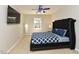 Bedroom with bed and mounted TV, complemented by a ceiling fan and window view at 1005 Fairfax Woods Dr, Apex, NC 27502