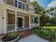 Inviting front porch with stone accents, brick steps, white railing and decorative plants at 1005 Fairfax Woods Dr, Apex, NC 27502
