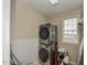 Well-lit laundry room featuring stacked washer and dryer for efficient space-saving at 1005 Fairfax Woods Dr, Apex, NC 27502