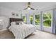 Bedroom with large bed, natural light, side table, and bright blue curtains at 105 Jolyn Pl, Chapel Hill, NC 27517