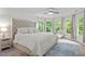 Bright bedroom features large bed, ceiling fan, bay windows with curtains, and outside green view at 105 Jolyn Pl, Chapel Hill, NC 27517