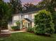Charming two-story home featuring a well-manicured lawn, mature trees, and a welcoming front porch at 105 Jolyn Pl, Chapel Hill, NC 27517