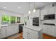 Spacious kitchen with a center island, white cabinets, modern appliances, and backyard access at 105 Jolyn Pl, Chapel Hill, NC 27517
