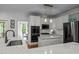 Bright, modern kitchen features white cabinets, marble countertops, stainless steel appliances, and an island at 105 Jolyn Pl, Chapel Hill, NC 27517