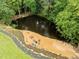 Aerial view of backyard pond with seating area and fire pit for outdoor relaxation and entertainment at 105 Jolyn Pl, Chapel Hill, NC 27517