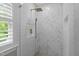 Modern glass shower with white tile in herringbone pattern, gold shower head and fixtures at 105 Jolyn Pl, Chapel Hill, NC 27517