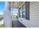 View from front porch with gray wood floors and view of neighboring property at 108 Hudson Dr, Princeton, NC 27569