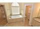 Relaxing bathroom with a large tub, window, and granite countertop vanity at 1126 Falling River Walk, Rocky Mount, NC 27804