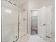 Modern bathroom with a glass-enclosed shower and an open door to a walk-in closet with shelves at 115 Snowy Orchid Ln, Smithfield, NC 27577