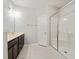 Bathroom featuring a glass door shower, single sink vanity with dark cabinets, and neutral tile floors at 115 Snowy Orchid Ln, Smithfield, NC 27577