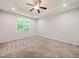 Spacious bedroom featuring a tray ceiling, ceiling fan, and a large window offering ample natural light at 115 Snowy Orchid Ln, Smithfield, NC 27577