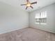 Bedroom featuring a ceiling fan, carpet, and a window providing natural light, creating a comfortable space at 115 Snowy Orchid Ln, Smithfield, NC 27577