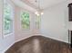 Bright dining area featuring many windows, a modern chandelier, and wood-look floors at 115 Snowy Orchid Ln, Smithfield, NC 27577
