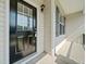Covered front porch with a black front door and a window and sidelight at 115 Snowy Orchid Ln, Smithfield, NC 27577