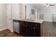 Kitchen island boasts granite countertops, stainless steel dishwasher, and dark cabinets at 115 Snowy Orchid Ln, Smithfield, NC 27577