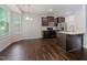 Open kitchen and dining area with modern stainless appliances, dark cabinetry, and wood-look floors at 115 Snowy Orchid Ln, Smithfield, NC 27577