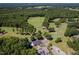 Expansive aerial view of a golf course with meticulously manicured greens, surrounded by lush trees and a clubhouse at 1176 Sagamore Dr, Louisburg, NC 27549