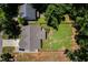 Aerial view of the property featuring a well-manicured lawn, wooden fencing, and tree coverage at 1176 Sagamore Dr, Louisburg, NC 27549