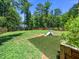Expansive backyard with lush grass, a small playground, and a view of the surrounding trees at 1176 Sagamore Dr, Louisburg, NC 27549