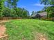 Large backyard with a wooden fence, manicured lawn, and access to the back of the house at 1176 Sagamore Dr, Louisburg, NC 27549