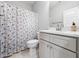 Bathroom featuring a sleek vanity and a shower with a decorative shower curtain, complemented by patterned floor tiles at 1176 Sagamore Dr, Louisburg, NC 27549