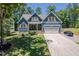 Charming two-story blue home featuring yellow shutters, a well-manicured lawn, and an attached two-car garage at 1176 Sagamore Dr, Louisburg, NC 27549