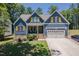 Charming two-story home with blue siding, a two-car garage, and a well-manicured front yard at 1176 Sagamore Dr, Louisburg, NC 27549