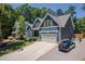 Beautiful two-story blue home with yellow shutters, two-car garage, and long driveway surrounded by lush greenery at 1176 Sagamore Dr, Louisburg, NC 27549