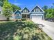 Beautiful two-story blue home with yellow shutters, two-car garage, and expansive front lawn at 1176 Sagamore Dr, Louisburg, NC 27549