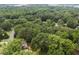 An aerial view of the property showcases its wooded setting with a glimpse of the home and its well-concealed location at 1205 Willow Dr, Chapel Hill, NC 27517