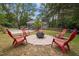 Outdoor fire pit surrounded by red Adirondack chairs on a stone patio, perfect for gatherings at 1205 Willow Dr, Chapel Hill, NC 27517