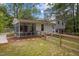 Back exterior featuring a screened-in porch, small deck, and wooden fence, all set in a well-maintained yard at 1205 Willow Dr, Chapel Hill, NC 27517