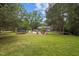 Expansive backyard featuring an open lawn, a charming firepit area, and a trampoline for outdoor enjoyment at 1205 Willow Dr, Chapel Hill, NC 27517