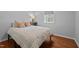 Cozy bedroom with hardwood flooring, a bedside table, and a comfortable striped bed at 1205 Willow Dr, Chapel Hill, NC 27517