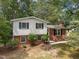 Charming home featuring a combination of brick and siding, complemented by dark shutters and mature landscaping at 1205 Willow Dr, Chapel Hill, NC 27517