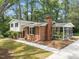 Charming home with brick chimney, screened porch, and well-manicured lawn, shaded by mature trees at 1205 Willow Dr, Chapel Hill, NC 27517