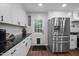 Bright kitchen with stainless steel appliances, white cabinets, dark countertops, and a door leading to the outside at 1205 Willow Dr, Chapel Hill, NC 27517