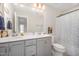 Bright bathroom features double vanity, toilet, mirror and patterned shower curtain at 123 Teaser Dr, Fuquay Varina, NC 27526