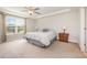 Bright bedroom with large window, ceiling fan, tray ceiling, and neutral decor at 123 Teaser Dr, Fuquay Varina, NC 27526