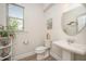 Elegant powder room featuring pedestal sink, decorative mirror, and natural lighting at 123 Teaser Dr, Fuquay Varina, NC 27526