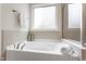 Bathroom soaking tub with tile surround and chrome faucet and fixtures at 1320 Cozy Oak Ave, Cary, NC 27519