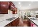 Kitchen featuring stainless steel range top, granite countertops, and stylish cabinetry at 1320 Cozy Oak Ave, Cary, NC 27519